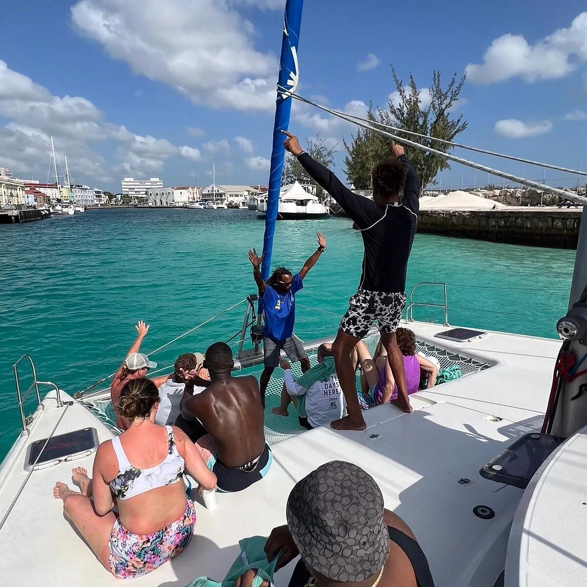 Guests sitting on the trampoline as Dreams leaves the Bridgetown careenage